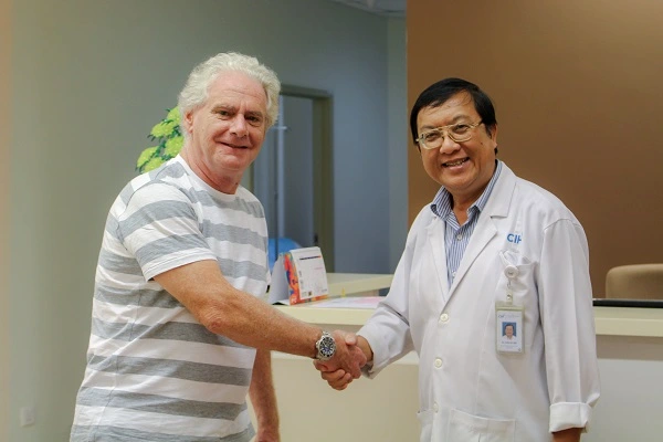 Vietnamese doctor and patient shaking hands - hospital room - gratitude