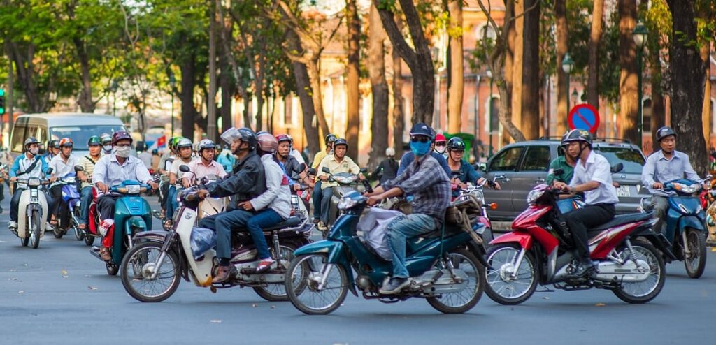 Busy street scene in Hanoi filled with motorbikes - motorbikes in Vietnam - dominant form of transport