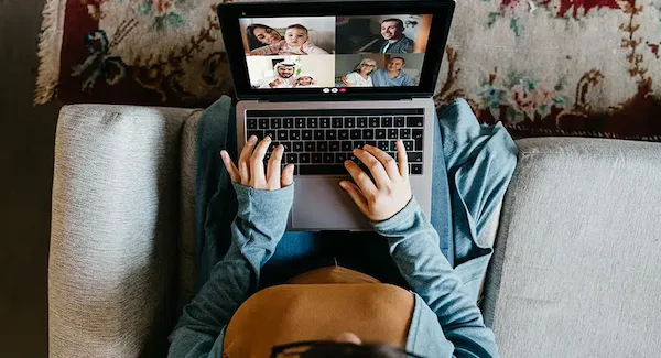 Video call with friends on laptop screen - laughing together - long distance connection