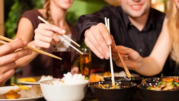 person using chopsticks to pick up food, not spearing