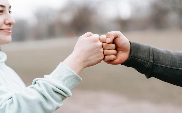  person bumping fists with a smile